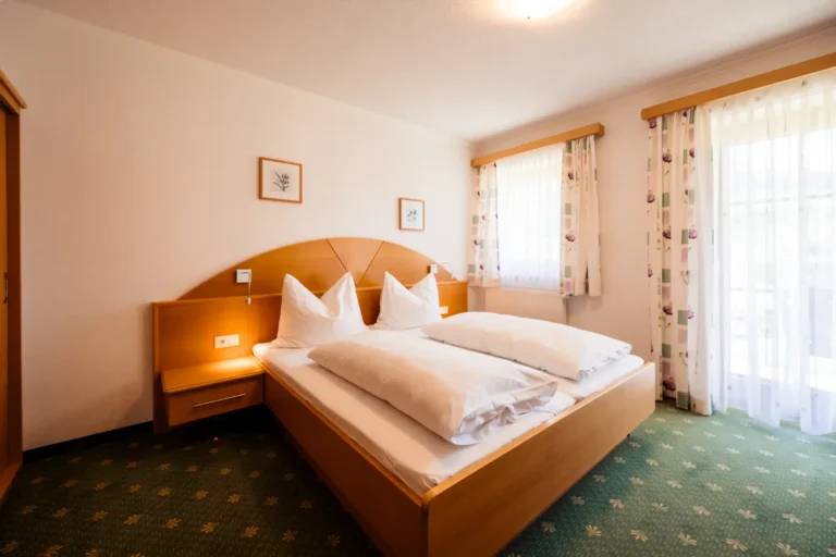 Das Schlafzimmer der Junior Suite im Alpenhof Wolayersee